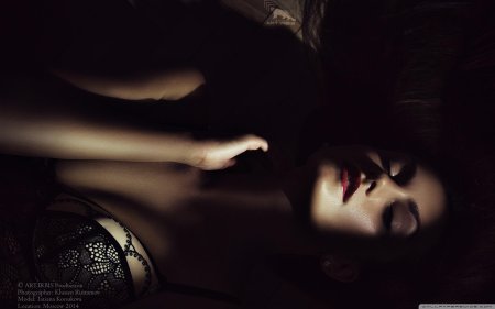 Девушка лежит в темноте