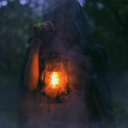 Человек с фонарем в лесу