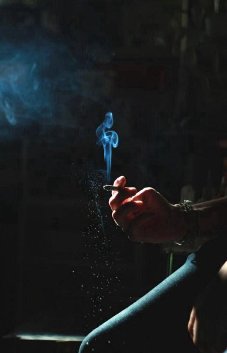 Парень курит в темноте