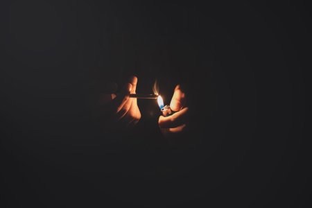 Парень курит сигарету в темноте