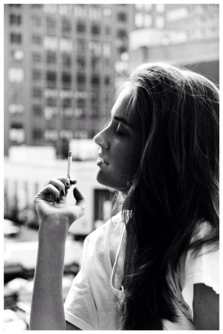 Красивая девушка курит сигарету