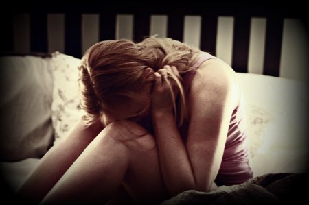 Девушка плачет на кровати