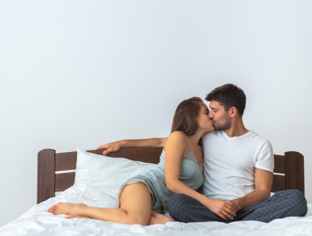 Пара целуется на кровати