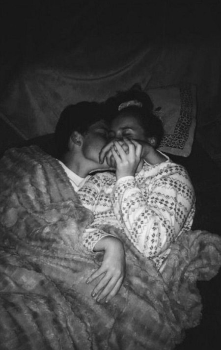 Парень обнимает девушку в темноте