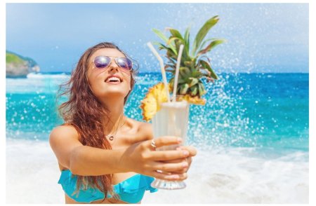 Девушка с коктейлем на пляже
