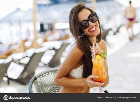 Девушка с коктейлем на пляже