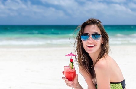 Девушка с коктейлем на пляже