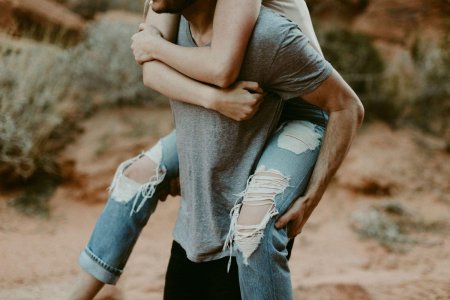 Обнимает девушку