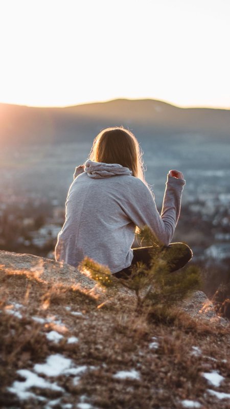 Девушка в горах со спины