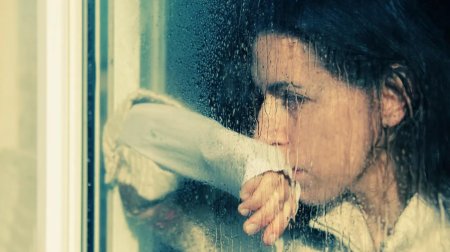 Женщина плачет у окна