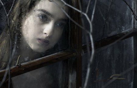 Девушка плачет у окна