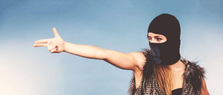 Девушка в балаклаве с пистолетом