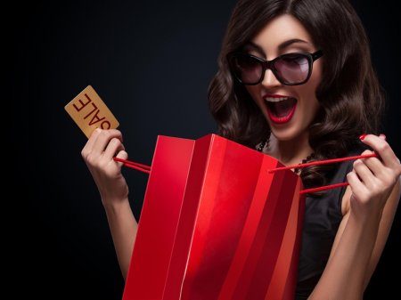 Девушка с покупками на красном фоне