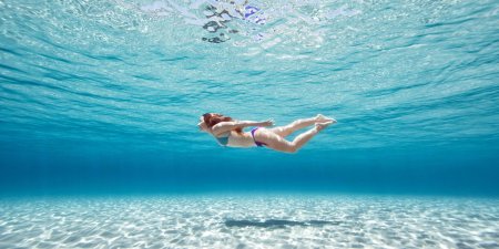 Девушка плавает в море