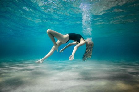 Девушка плавает в море