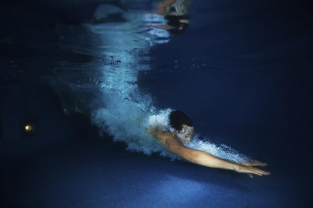 Девушка плывет в бассейне