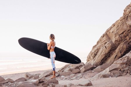 Девушка с доской для серфинга