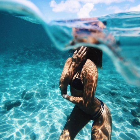 Девушка плавает в море