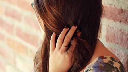 Накручивает волосы на палец