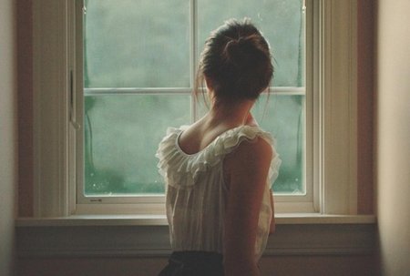 Девушка у окна со спины