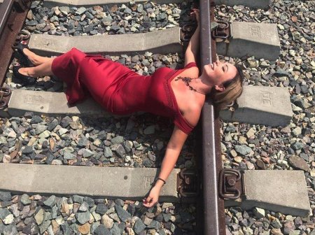 Девушка лежит на рельсах