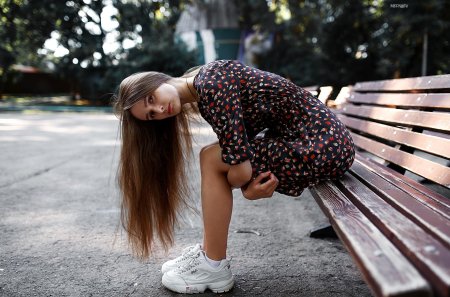 Девушка сидит на скамейке