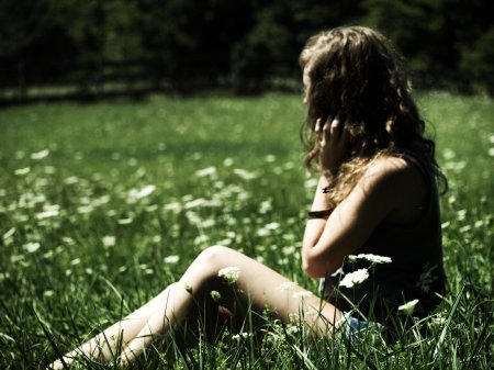 Девочка сидит на траве