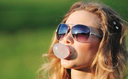 Надувает жвачку