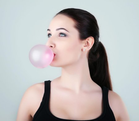 Надувает жвачку