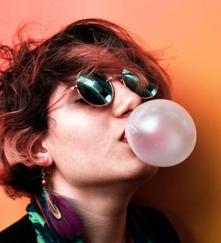 Надувает жвачку