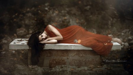 Девушка в длинном платье лежит