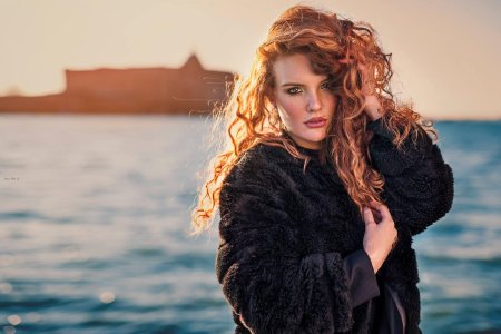 Рыжая кудрявая девушка и море