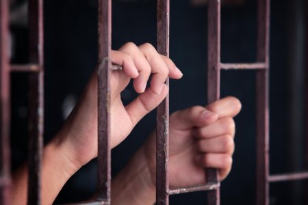 Женские руки за решеткой