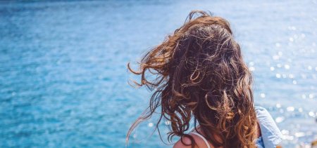 Девушка с кудрявыми волосами со спины