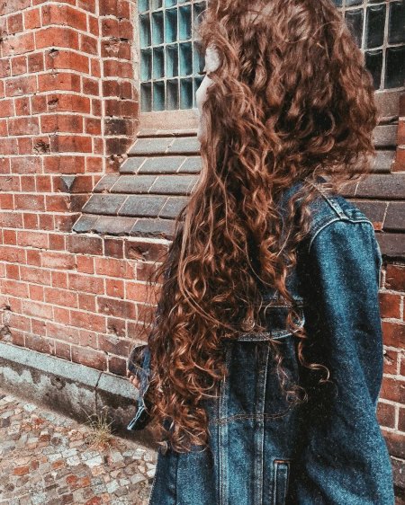 Девушка с кудрявыми волосами со спины