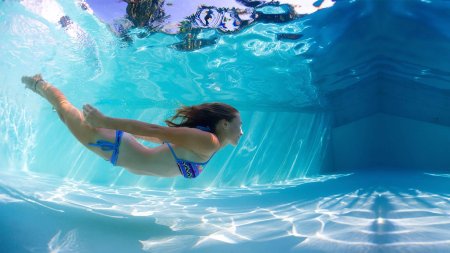 Девушка плывет в бассейне