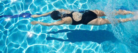 Девушка плавает в бассейне