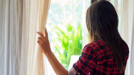 Девушка у окна со спины