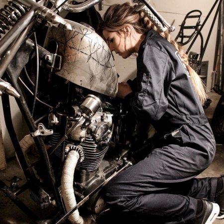 Девушка чинит мотоцикл