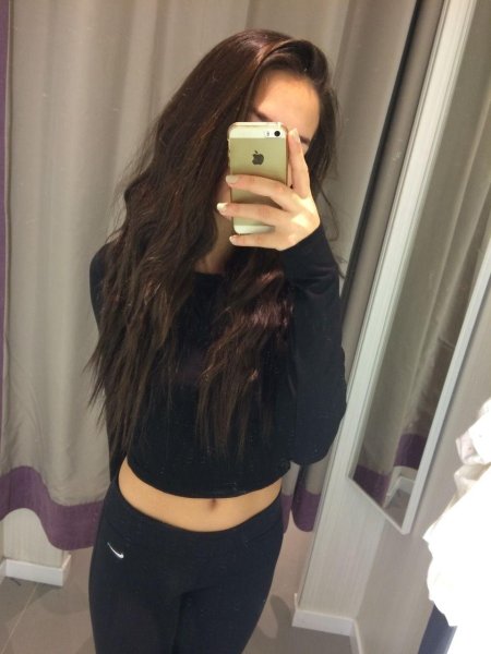 Девушка с темными волосами в зеркале