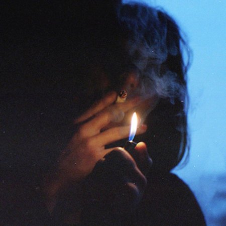 Курящая девушка в темноте