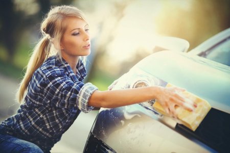 Девушка протирает машину