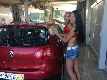 Девушка моет машину в купальнике