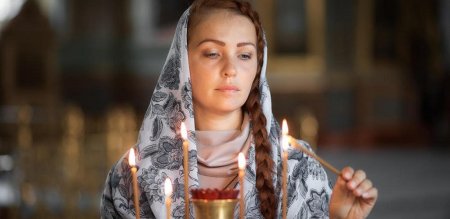 Женщина молится в храме
