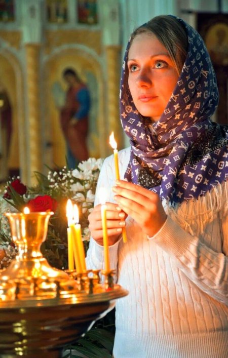 Женщина молится в храме