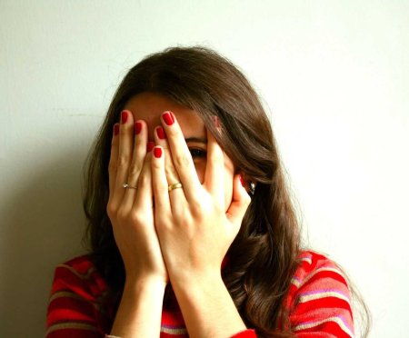Женщина закрывает лицо руками