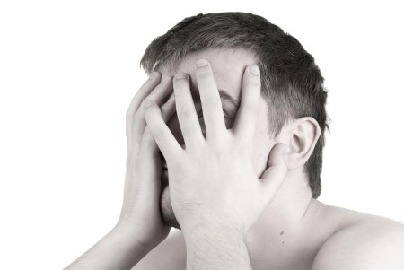 Мужчина закрывает лицо руками