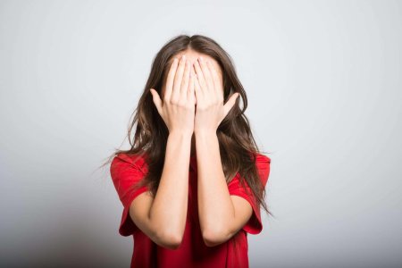 Девушка закрывает лицо рукой