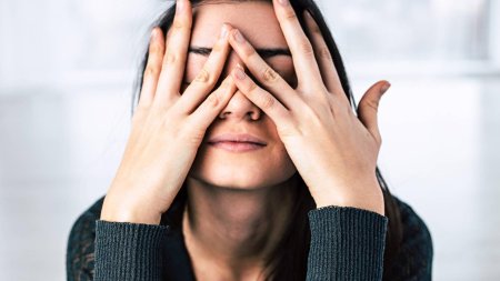 Девушка прикрывает лицо рукой