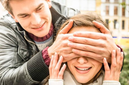 Человек закрывает глаза другому